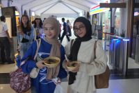 Dua pelanggan PT KAI Daop 2 memperlihatkan makanan gratis yang dibagikan Daop 2 Bandung di momen Hari Pangan Seduania. PJ/Dok