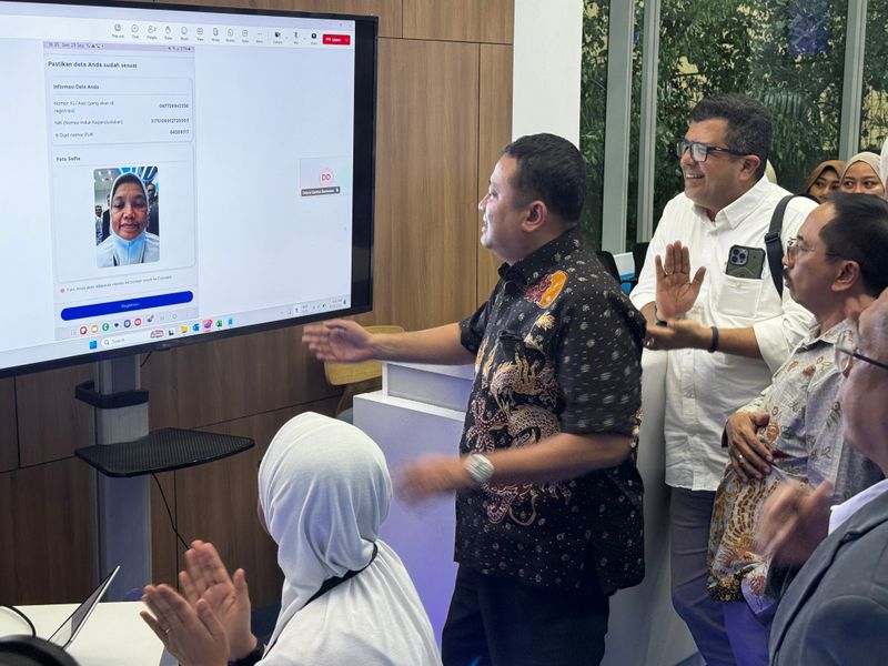 Ketua Tim Monitoring & Evaluasi Penyelenggara Jaringan dan Jasa serta Perlindungan Pengguna Kementrian Komunikasi dan Digital RI, Sumini (duduk), Direktur Jenderal Ekosistem Digital Kementrian Komunikasi dan Digital RI, Edwin Hidayat Abdullah (tengah), Direktur & Chief Regulatory Officer XLSMART, Merza Fachys (kiri belakang) dan Direktur Eksekutif ATSI, Marwan O.Baasir (kanan belakang) melakukan pengetesan registrasi kartu SIM  XLSMART  (XL, AXIS dan SMARTFREN) dengan teknologi pengenalan wajah di XL Center XLSMART Tower, Jakarta.  Selasa (29/9). Dok