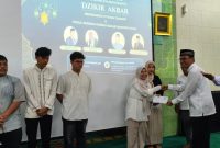 Ketum KAMABA Zulmauli Bahri menyerahkan bantuan ke salah satu mahasiswa korban banjir Aceh, disela Dizikir Akbar Peringatan 21 Tahun Tsunami. PJ/Dok