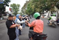 Sejumlah anggota PWI dibantu IKWI Kota Bandung membagikan paket takjil kepada pengguna jalan Selasa (24/2/2026). PJ/Dok