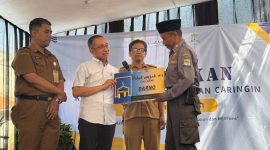 Ketua DPRD Kota Bandung Kang Asmul menyerahkan Paket Umrah kepada Pak Darno, salah satu petugas linmas di Kelurahan Caringin, Senin 11 Mei 2026. PJ/ Humpro DPRD Kota Bandung)